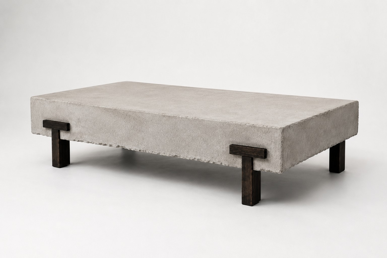 Full studio view of PIEZA 001 showing the asymmetrical placement of its two T-shaped wooden legs beneath the mineral-finish slab.