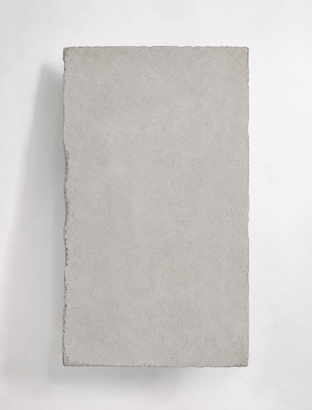 Overhead photograph of PIEZA 001, showing the top surface of the mineral-finish slab and its irregular edge.